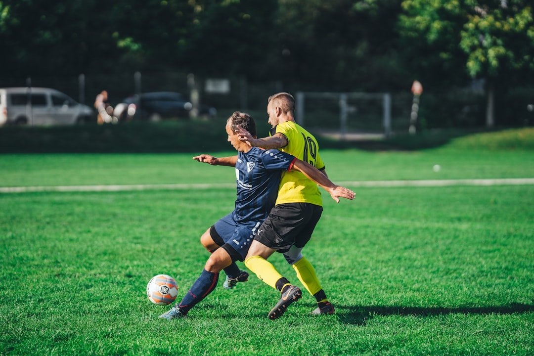 about-02 boy-in-blue-and-yellow-soccer-jersey-kicking-soccer-ball-on-green-grass-field-during-daytime-z8hty2q9dgy